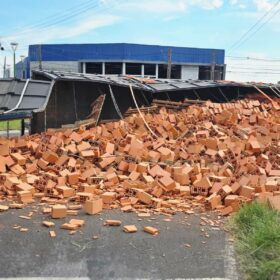 Fotos de Carreta tomba em rotatória e carga de lajotas fica espalhada na pista em Maringá